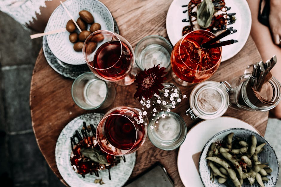 Aerial view of a rustic dining table with drinks and appetizers in an outdoor setting.